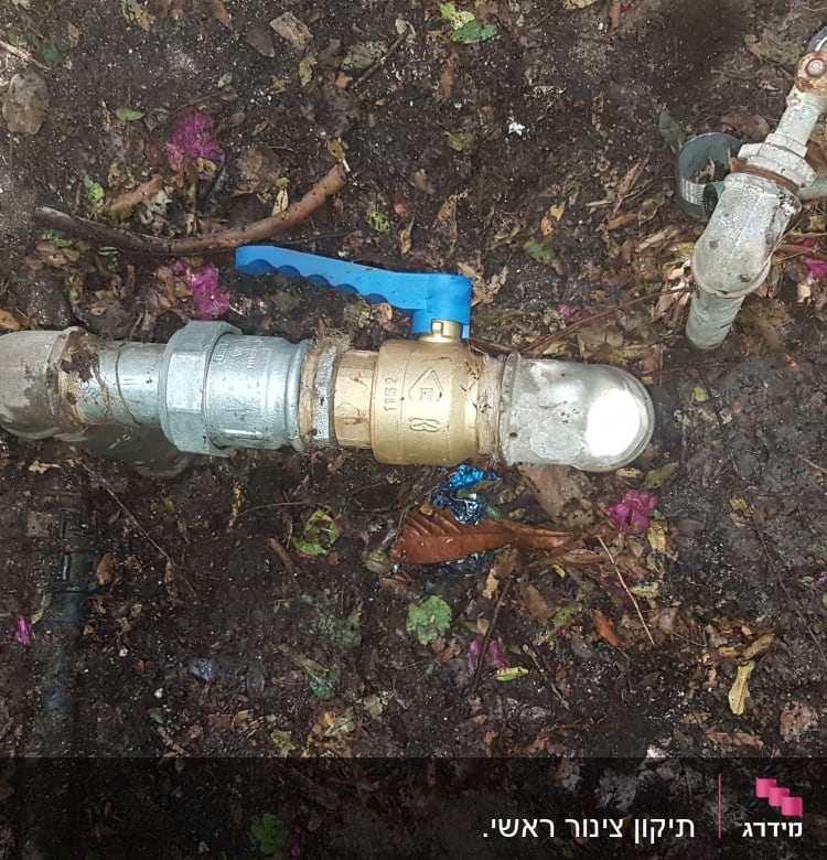 ברז פליז עם ידית כחולה על צינור מתכת